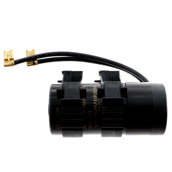 A black round Franke start capacitor with gold wires.