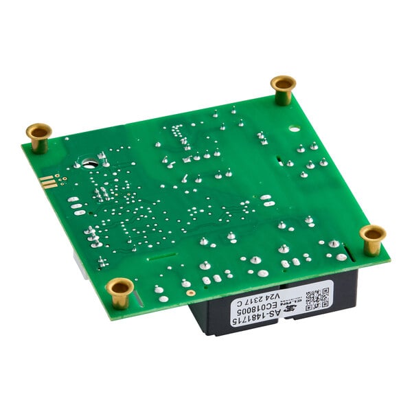 A green printed circuit board with various solder points, four brass mounting standoffs, and a label with barcodes and text visible on the side.