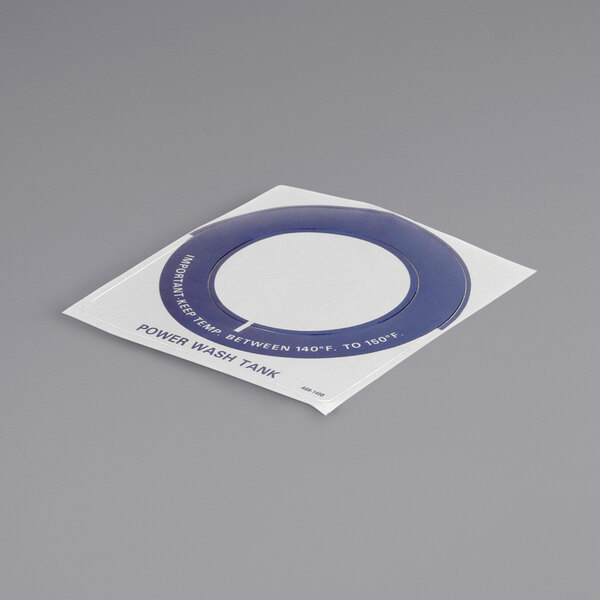 A white and blue circular sticker with blue text that reads "Stero Dcl Tem Ga Pwr Wash 140-160 Dg" on a grey surface.