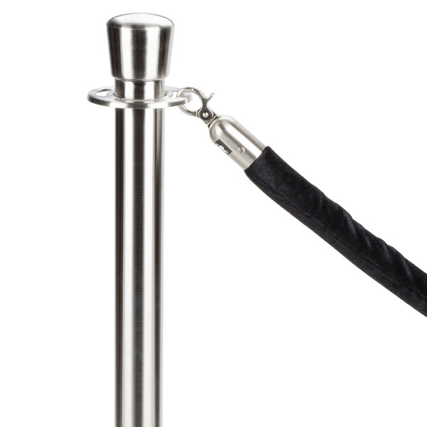 A black stanchion rope with satin silver ends attached to a pole.