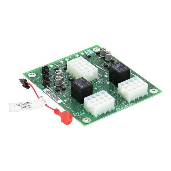 A green circuit board with a white plastic block and two black squares.