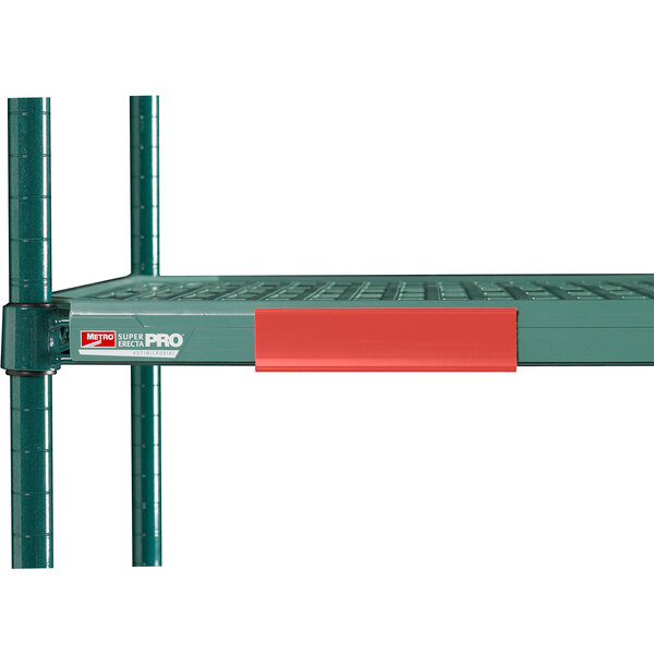 A red Metro shelf label on a green metal shelf.