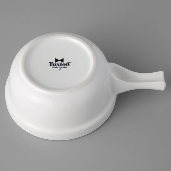 A white China bowl with a handle.