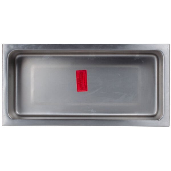 A rectangular stainless steel tray with a red label.