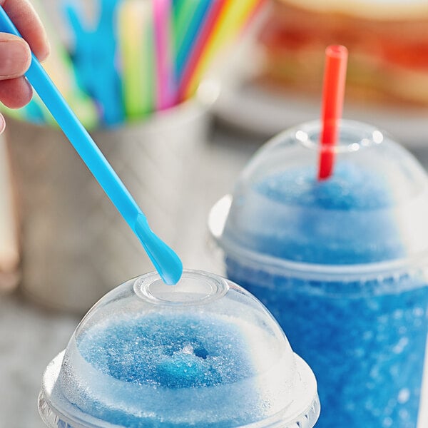 A person holding a Choice Super Jumbo spoon straw in a blue drink.