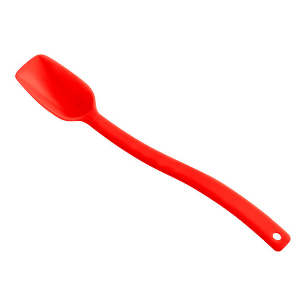 A red plastic spoon with a flat bottom.
