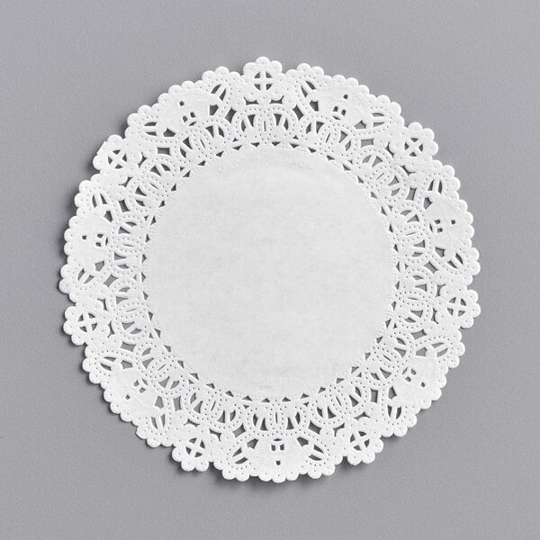 A 5" white Normandy lace doily on a gray surface.