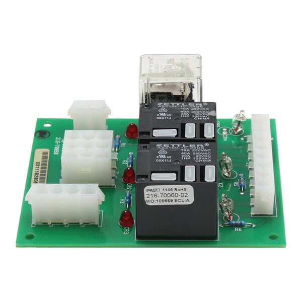 A green circuit board with two black and white electronic components.