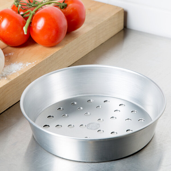 An American Metalcraft aluminum pizza pan with holes in it.