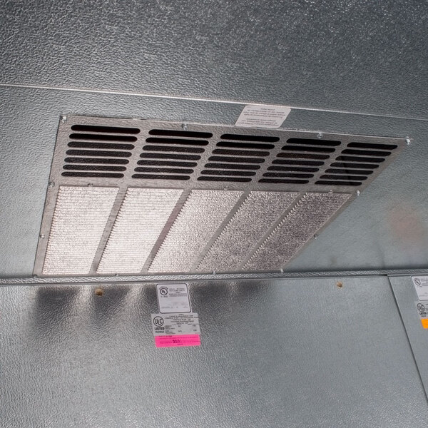 A metal vent with a fan on it on a Norlake Kold Locker.