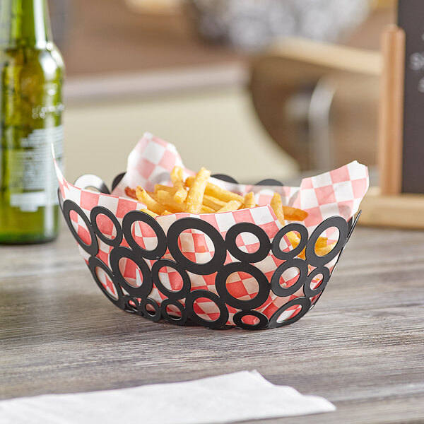 An American Metalcraft black oval basket of french fries on a table.