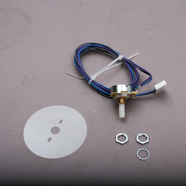 A close-up of a Middleby Marshall Potentiometer, a small white circle with holes on it.