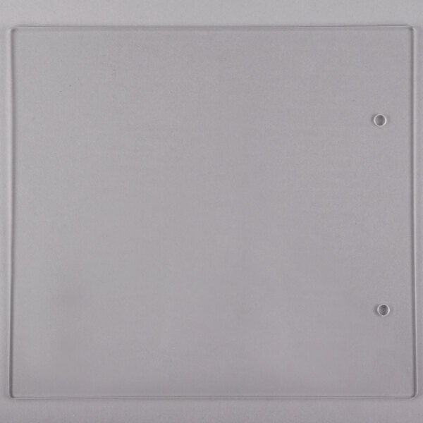 A clear plastic square panel with a small hole in it.