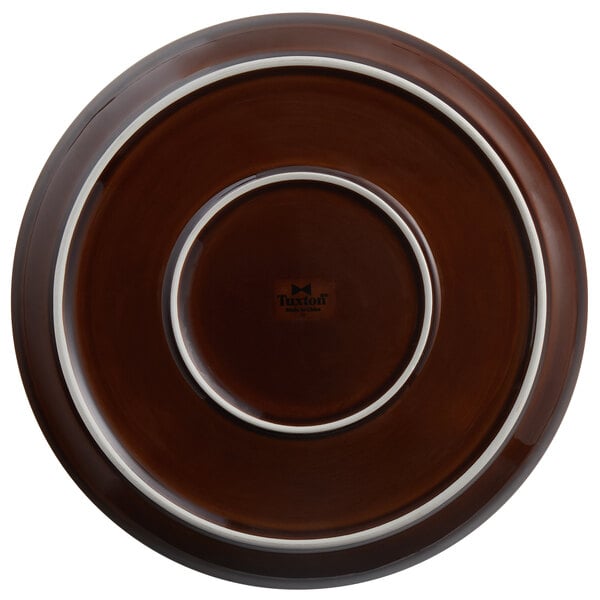 A brown plate with a white rim and border, with a logo on the box.