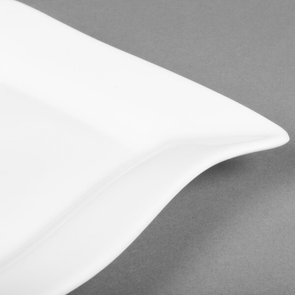 A CAC Miami bone white square porcelain plate with a curved edge on a gray surface.