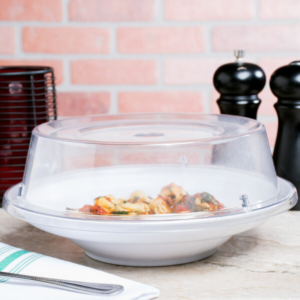 A clear Carlisle polycarbonate plate cover over a bowl of pasta and vegetables.