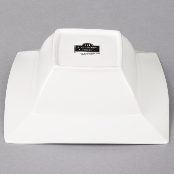 A white square bowl with a black label.