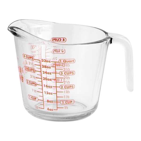 A clear glass Anchor Hocking measuring cup with red writing and a red handle.