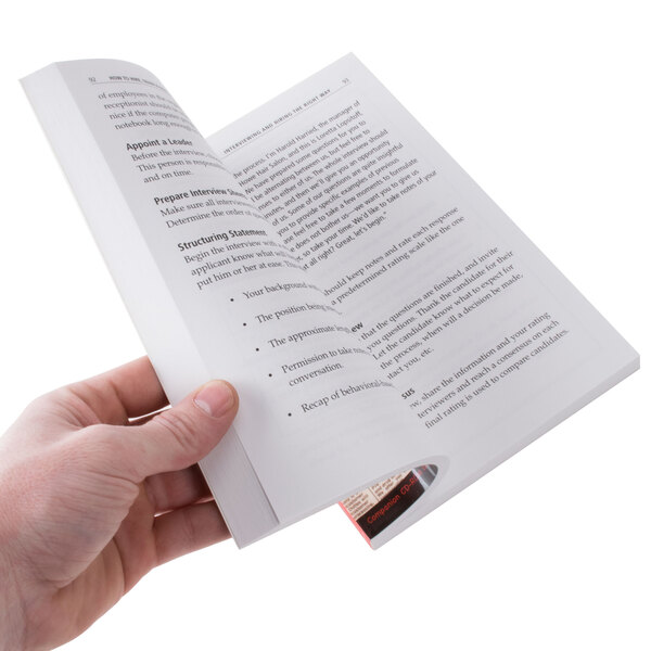 A person holding the book "How to Hire, Train & Keep the Best Employees"