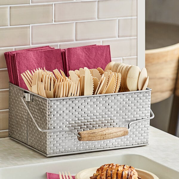 A Tablecraft stainless steel flatware caddy on a counter with utensils and forks in it.