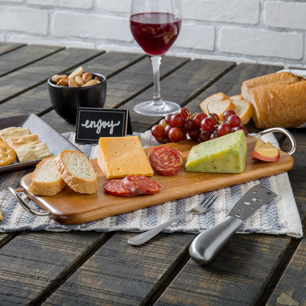 A Tablecraft acacia wood rectangular display board with cheese and bread on a table.