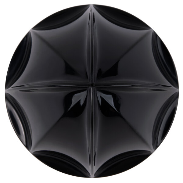 A black circular juice reamer with a cross design on it.