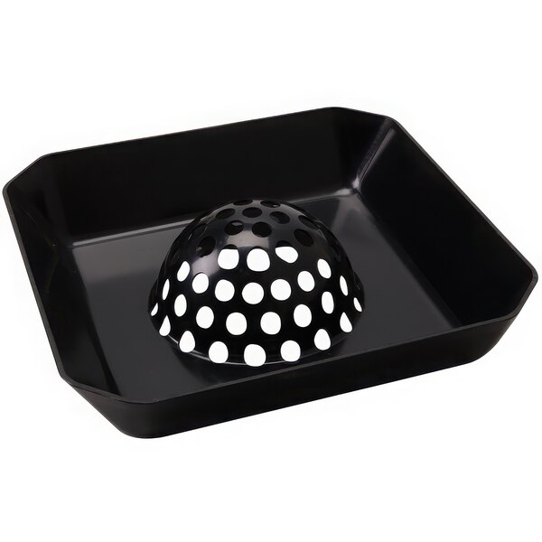 A black tray with a black round object with white dots on it.