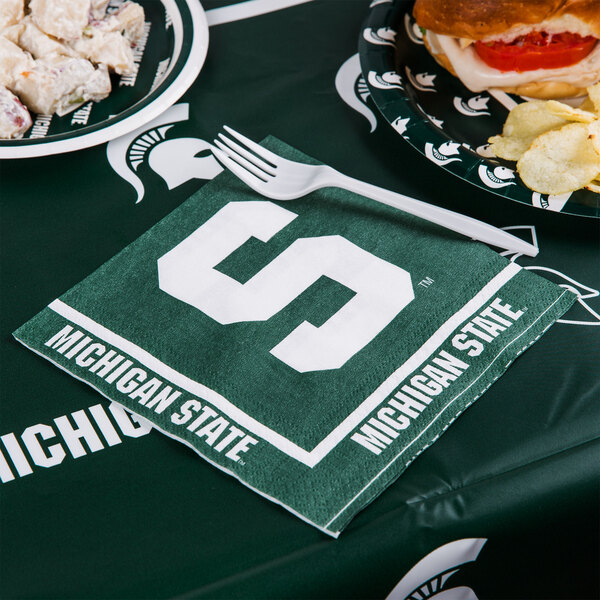 a napkin with a logo on it and a plate of food on a table