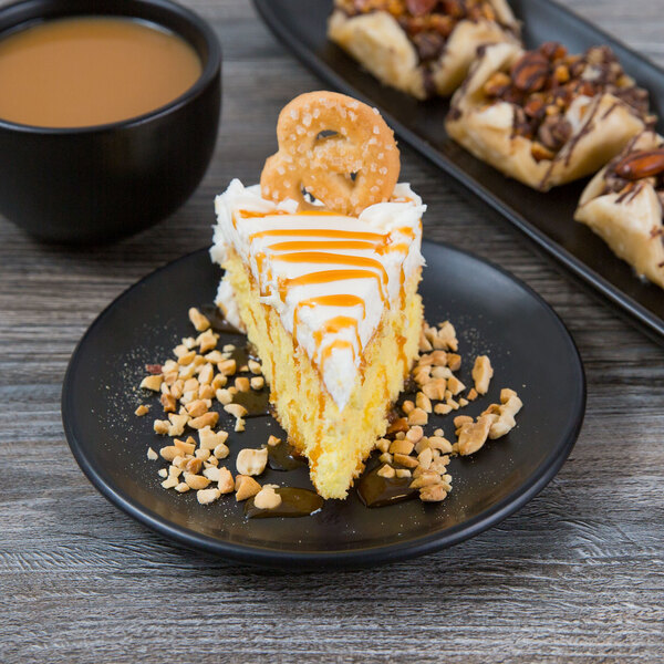 A piece of cake with nuts and caramel on a Libbey Driftstone Onyx satin matte porcelain coupe plate.