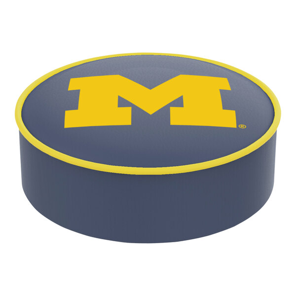 A grey bar stool seat cover with a yellow letter M and blue border.