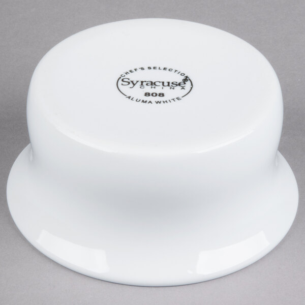 A white Libbey porcelain casserole dish with black text on the table.