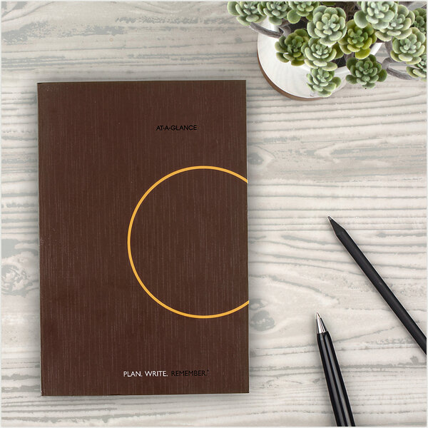 An At-A-Glance planning notebook open to a page with a circle and pen.