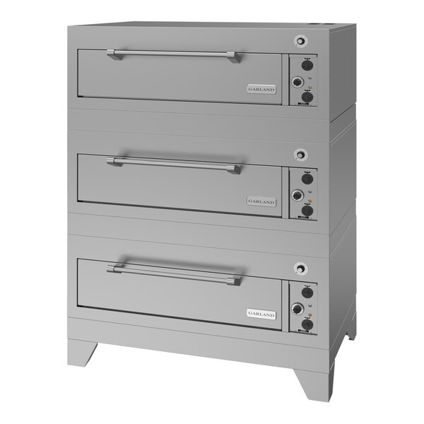 A triple deck electric pizza oven with stainless steel construction and control knobs on the right side.