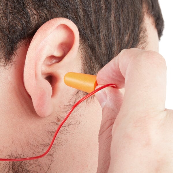 Person putting corded disposable earplugs in their ear