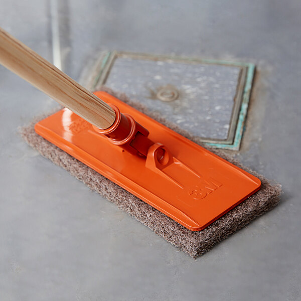 A 3M Doodlebug orange pad holder with a wooden handle.