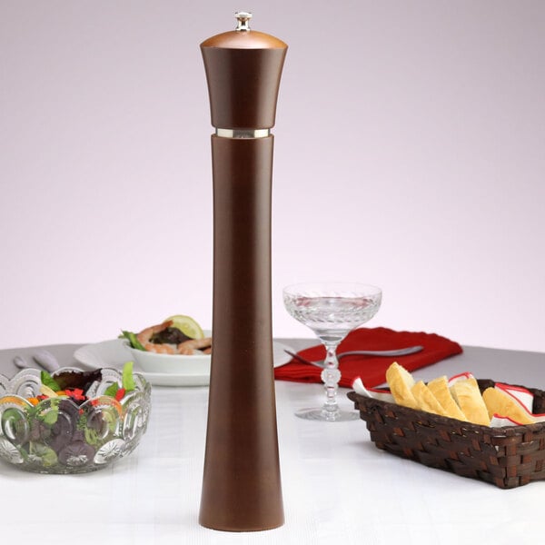 A wooden Chef Specialties Pueblo salt mill on a table.