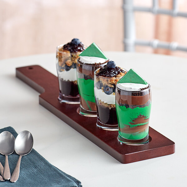 An Acopa mahogany flight paddle holding pub tasting glasses filled with desserts.