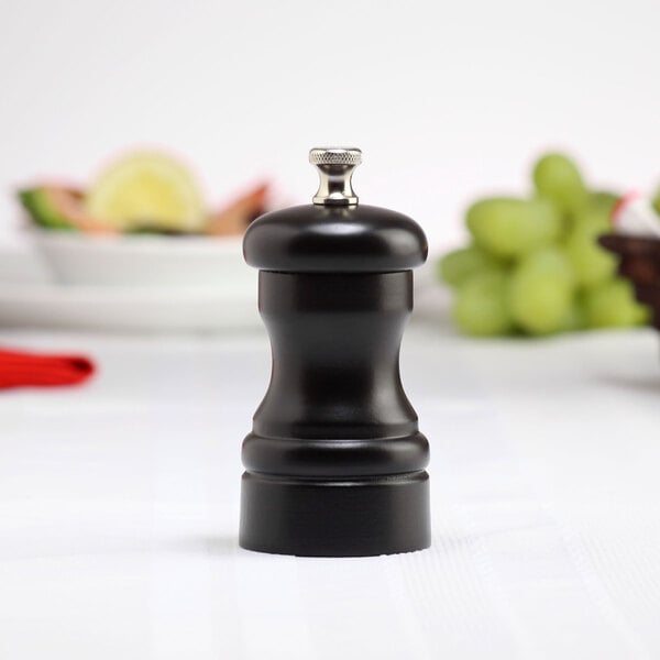 A black Chef Specialties Capstan Ebony pepper mill on a table.