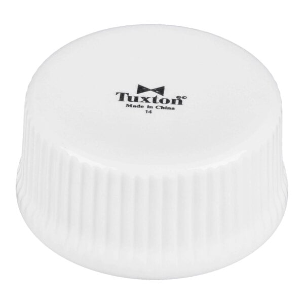 A white porcelain fluted ramekin turned upside down with the Tuxton brand logo visible on the bottom.