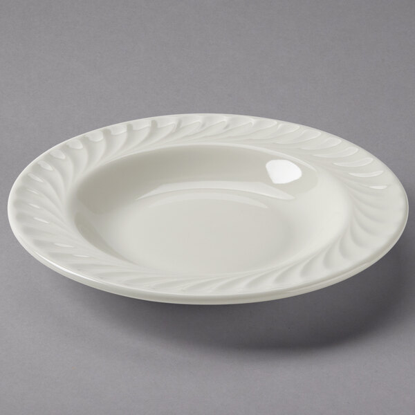 A white Tuxton china bowl with a swirl rim.