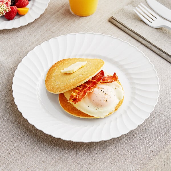 A WNA Comet white plastic plate with a pancake, egg, and bacon on it.