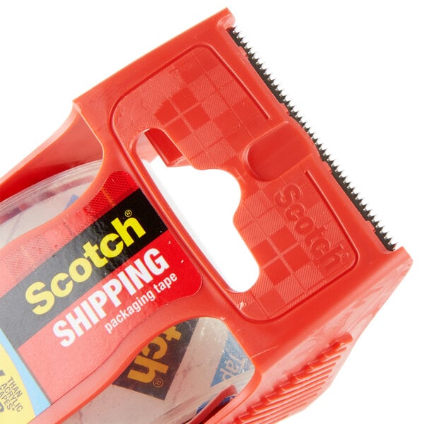 A red 3M Scotch packaging tape dispenser in a clear plastic container.