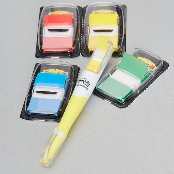 A 3M package containing yellow, blue, and white Post-It flags with a yellow highlighter.