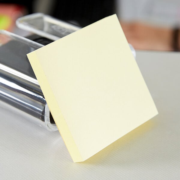 A 3M Canary Yellow Post-It note pad on a counter.