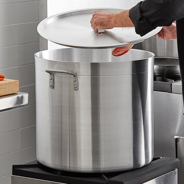 A person using a Choice aluminum pot cover to cook food.