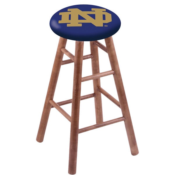 A wooden Holland Bar Stool with a blue Notre Dame seat.