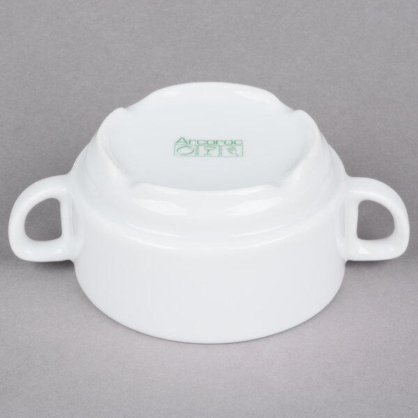 An Arcoroc white porcelain soup bowl with two handles.