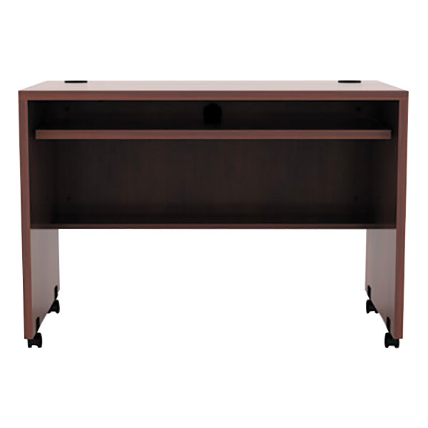 A medium cherry desk with wheels.