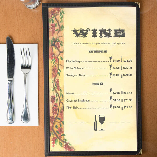 Menu paper with a Mediterranean villa design on a table with wine glasses and silverware.