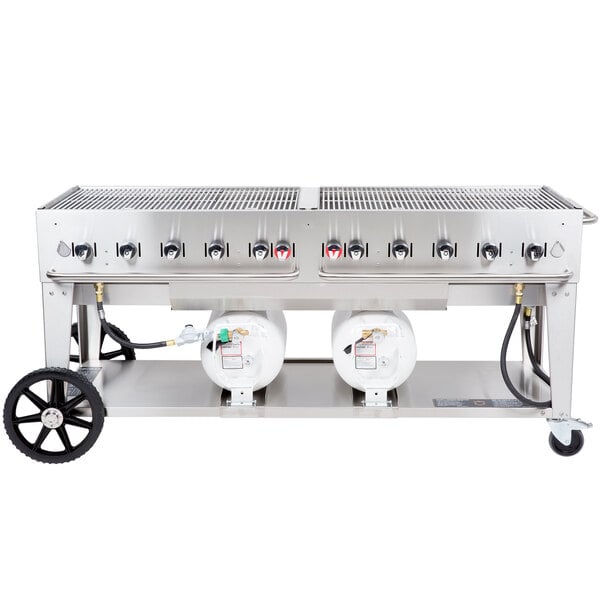 A large stainless steel Crown Verity outdoor grill with two horizontal propane tanks.